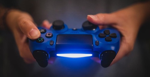 Two hands holding a blue game controller